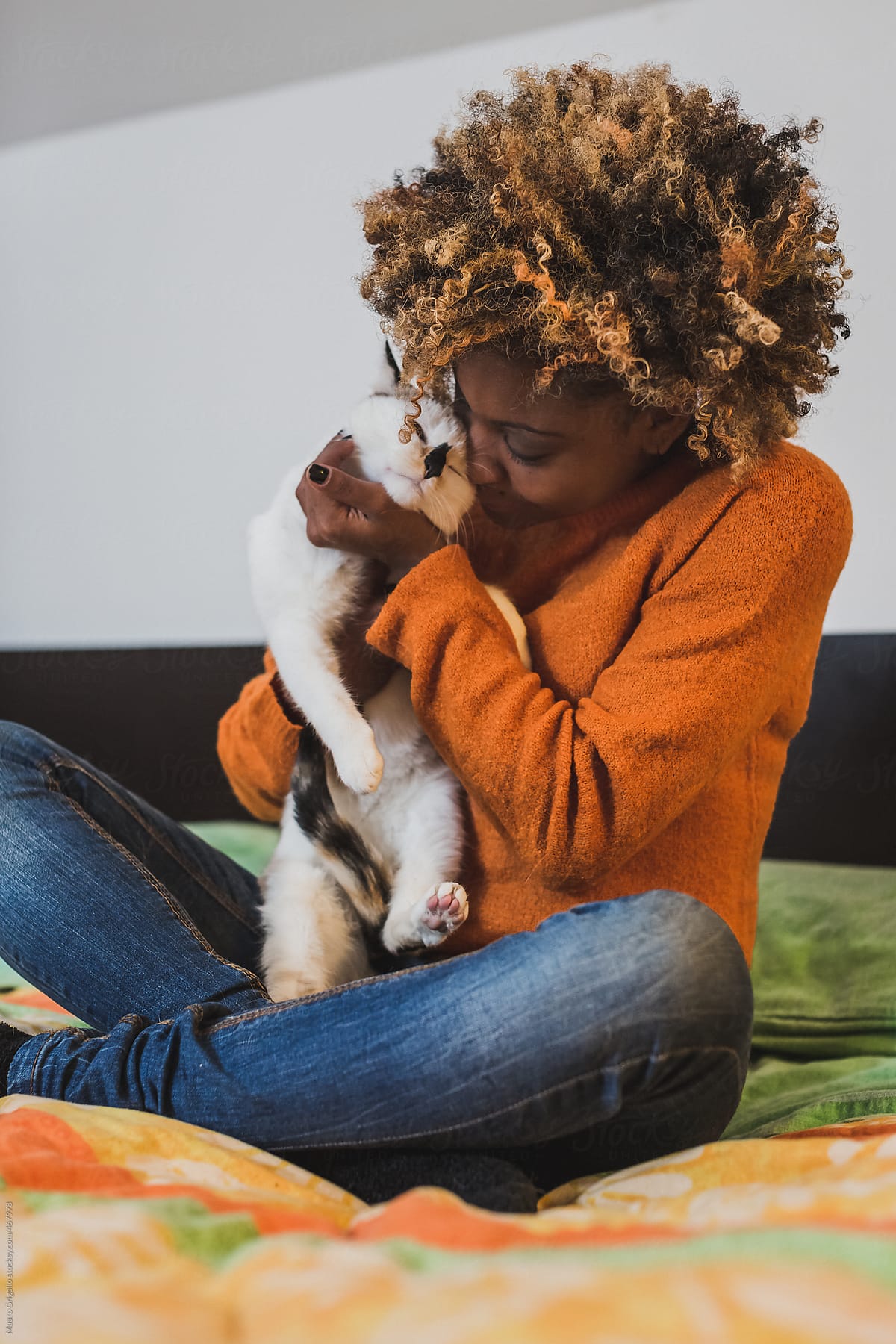 Afro woman with her cat on the bed