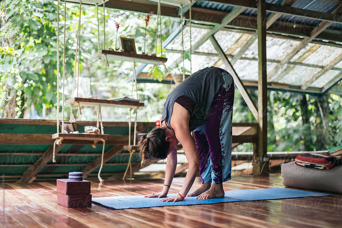 Woman doing yoga in a cozy outdoor wooden cabin