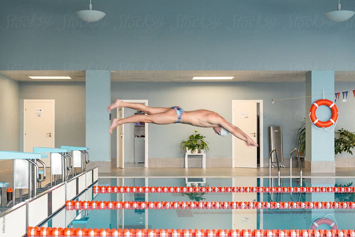 Swimmer in moment of jumping into pool