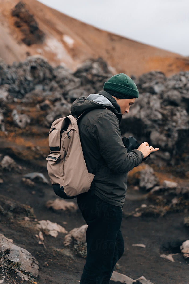 Hiker Man lost on lava field checking navigation map on phone