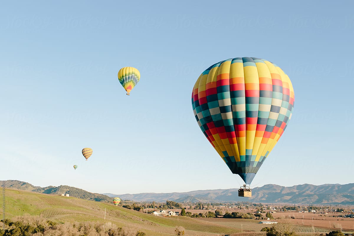 Hot air balloons and fields or hills