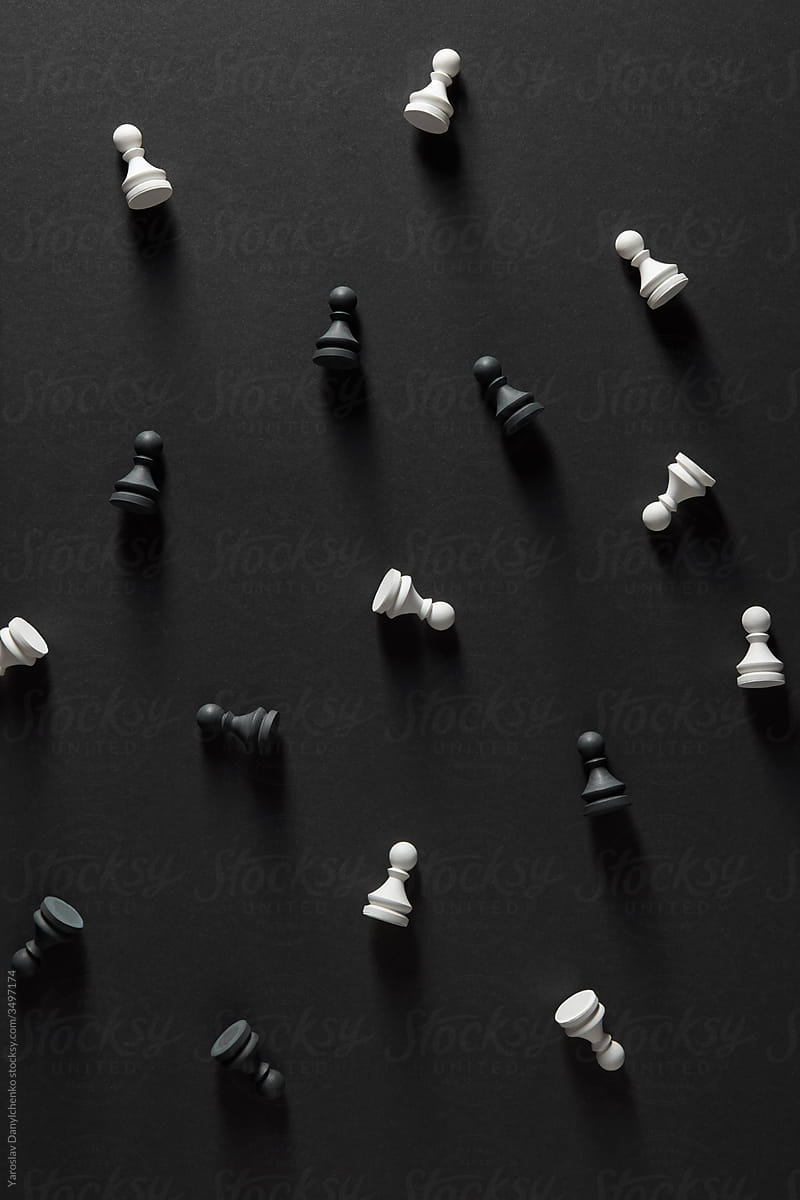 Pattern from black and white pawns on a dark surface.