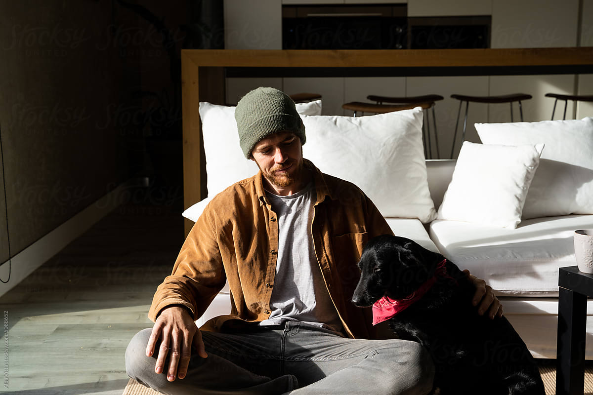 man with dog at home sofa