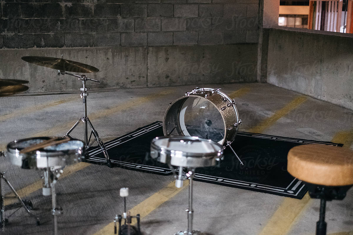 Drum kit pieces set up in a parking garage