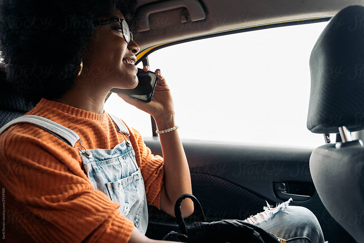 Afro Woman Using Mobile Phone Into The Car