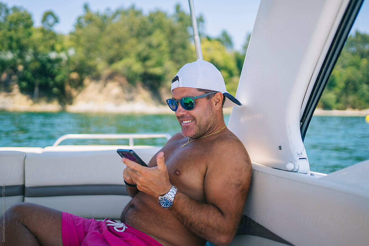 Man browsing smartphone in boat