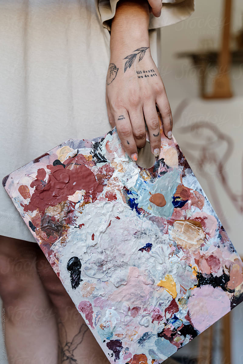 Closeup of hand holding color palette in artist studio