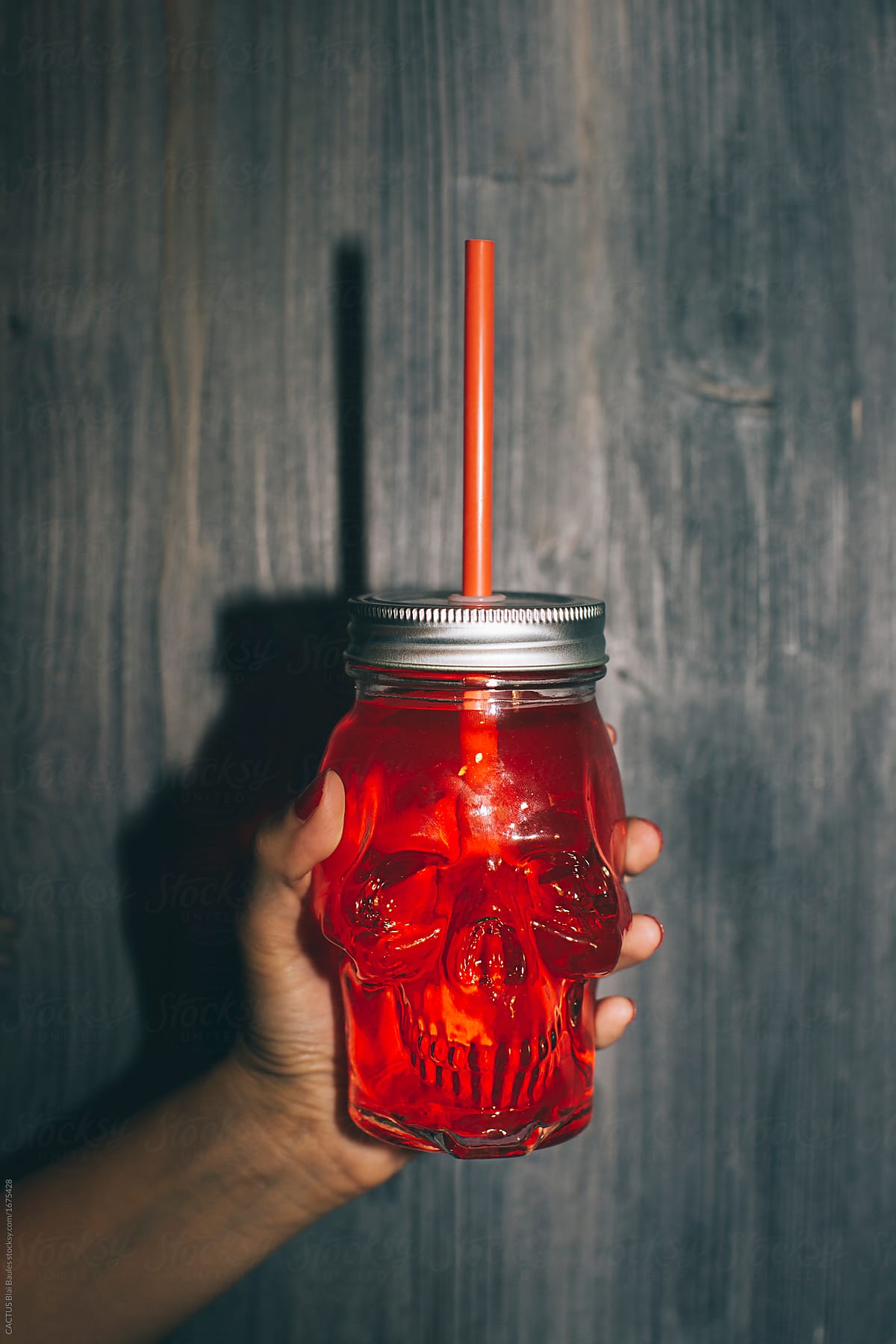 Skull shaped glass with red drink inside