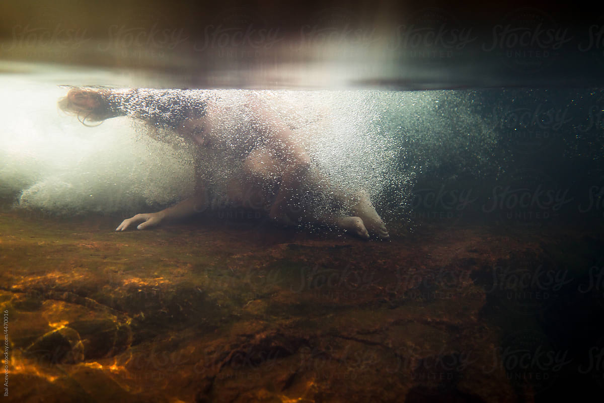 Underwater woman inside river water stream