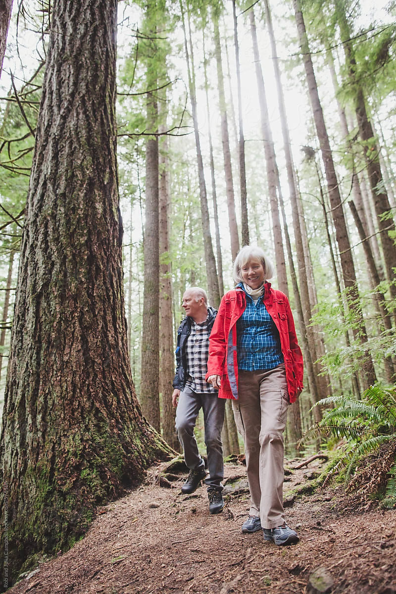 Older, Couple Hiking Together In Forest Nature by Rob And Julia