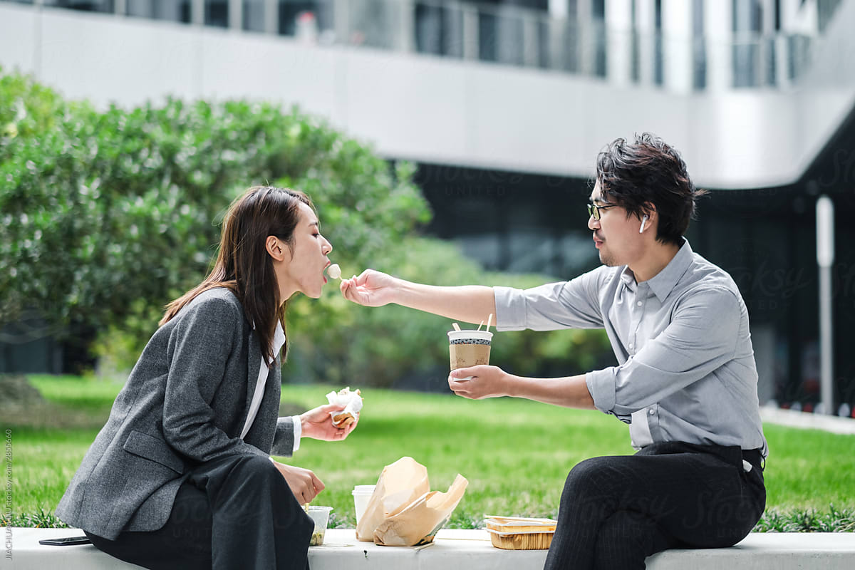 Businessman And Businesswoman Eating Lunch Together