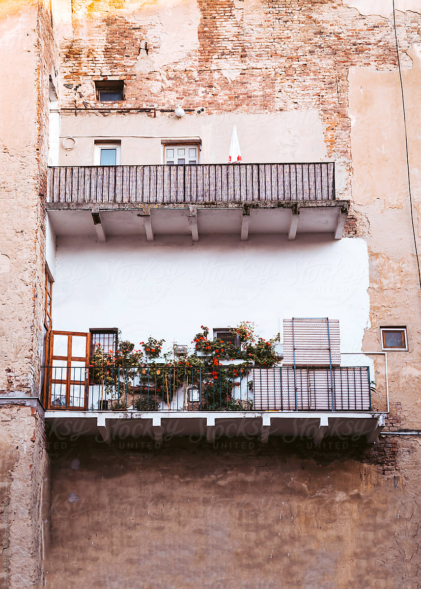An ugly house with a lovely balcony with plants and flowers
