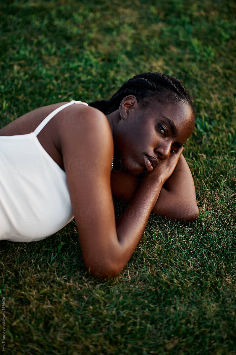 Portrait Of A Beautiful Black Woman Laying Down In The Grass. by