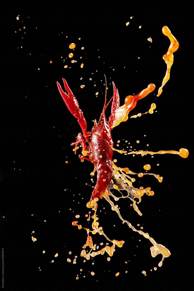 Leaping crayfish on a dark background with a sauce