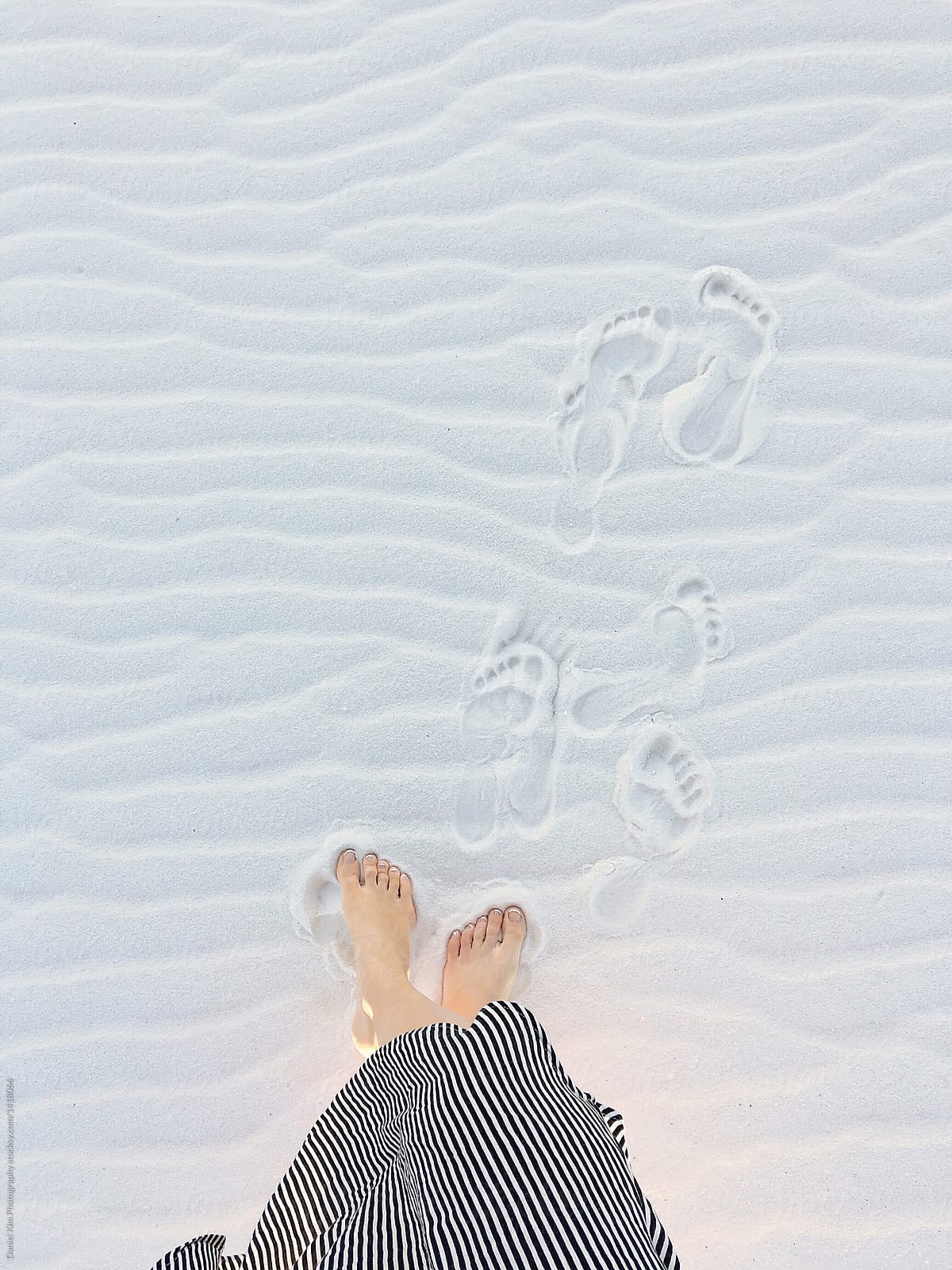 Top view of foot prints in soft white sand