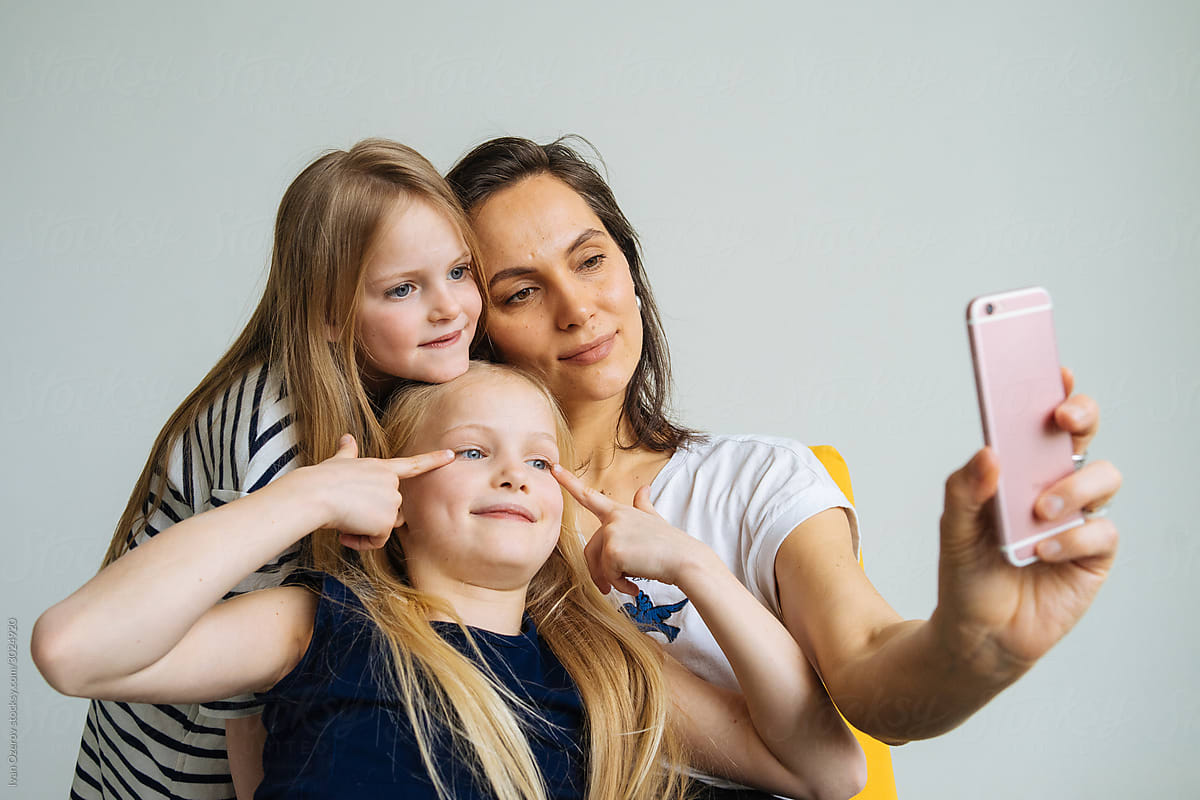 mom with two daughters takes a selfie