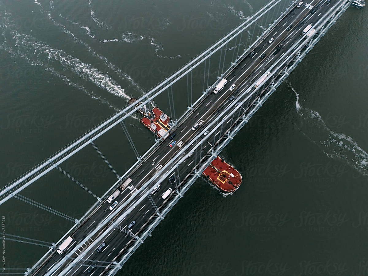 Aerial View of Ship Passing Under Bridge