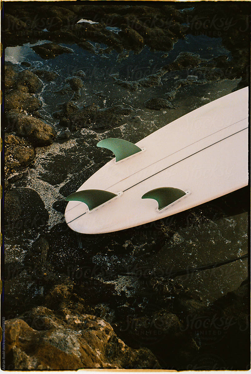 Surfboard Perched on Rocky Shores