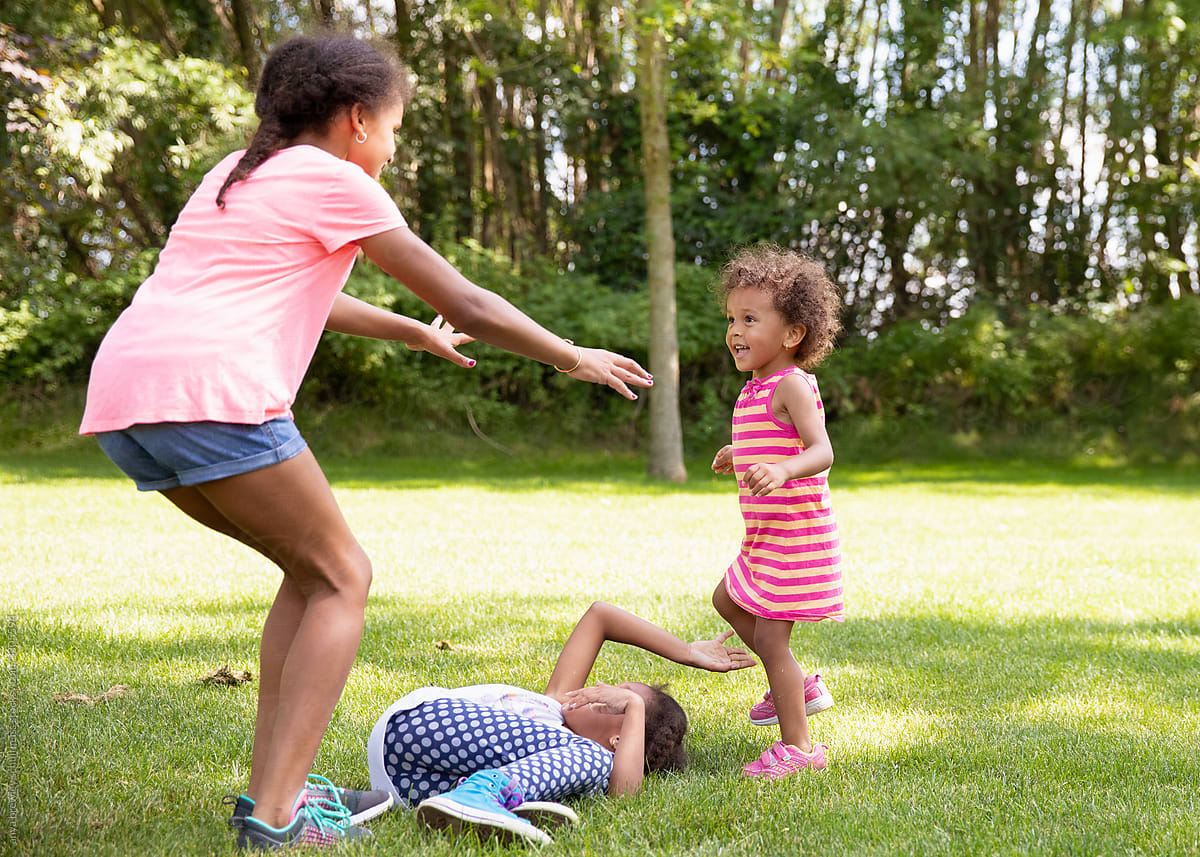 Young girl reaching forward to tag her younger sister