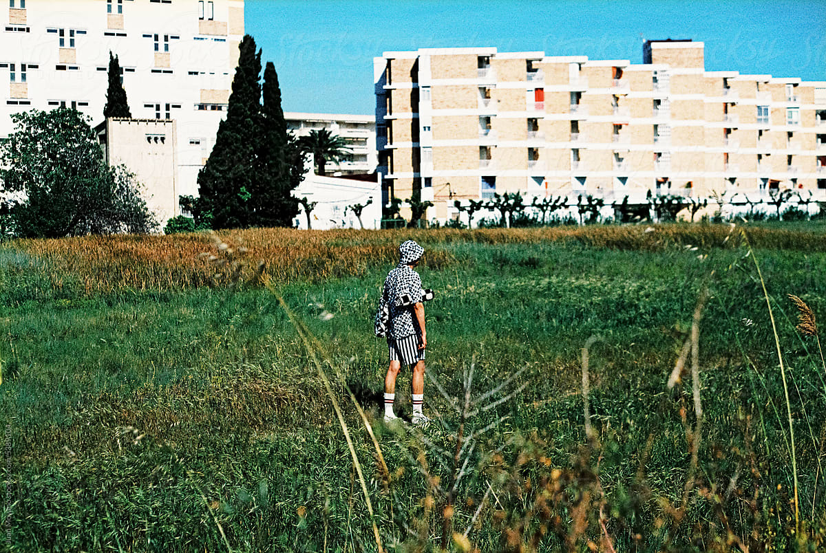 man walks next to an apartment complex, 35mm film