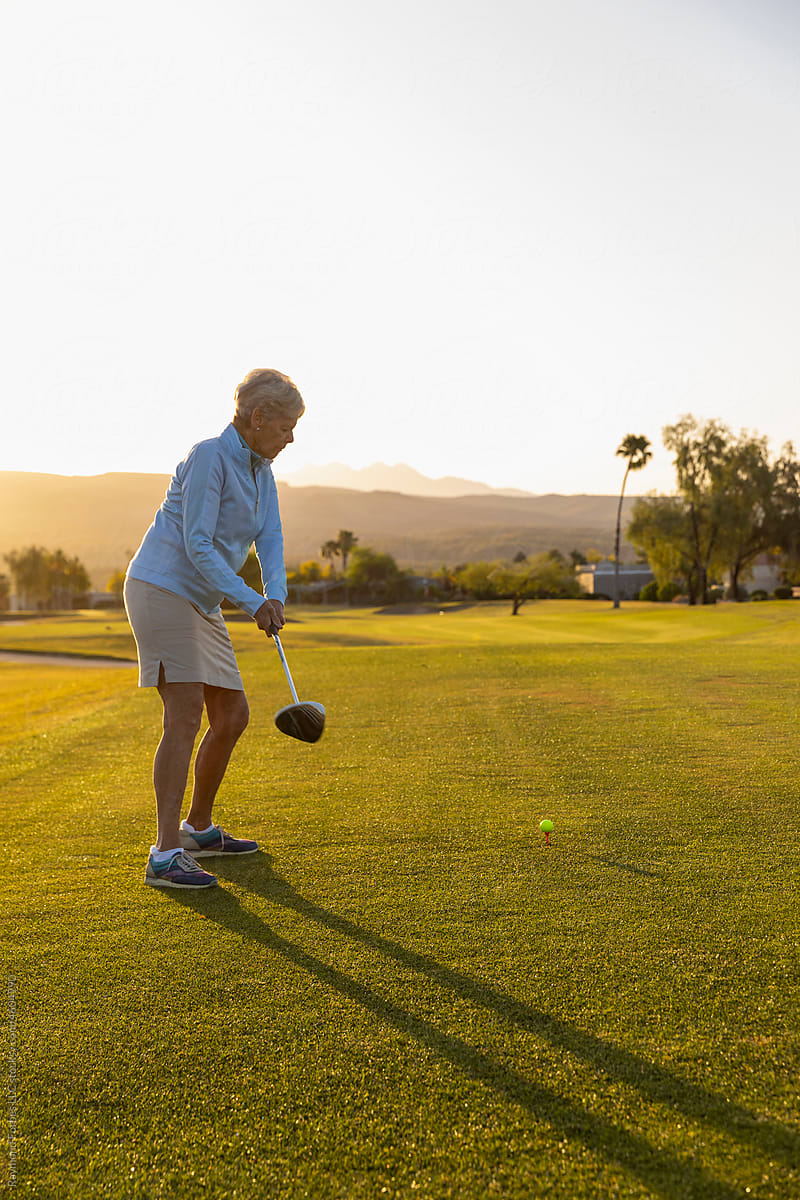 Healthy Senior Citizen Woman Playing Golf in backswing