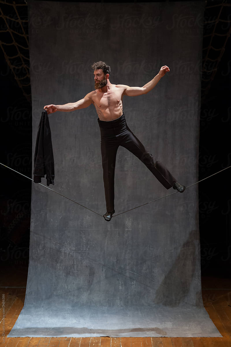 Shirtless Man balancing on a slackwire in stunning pose 01