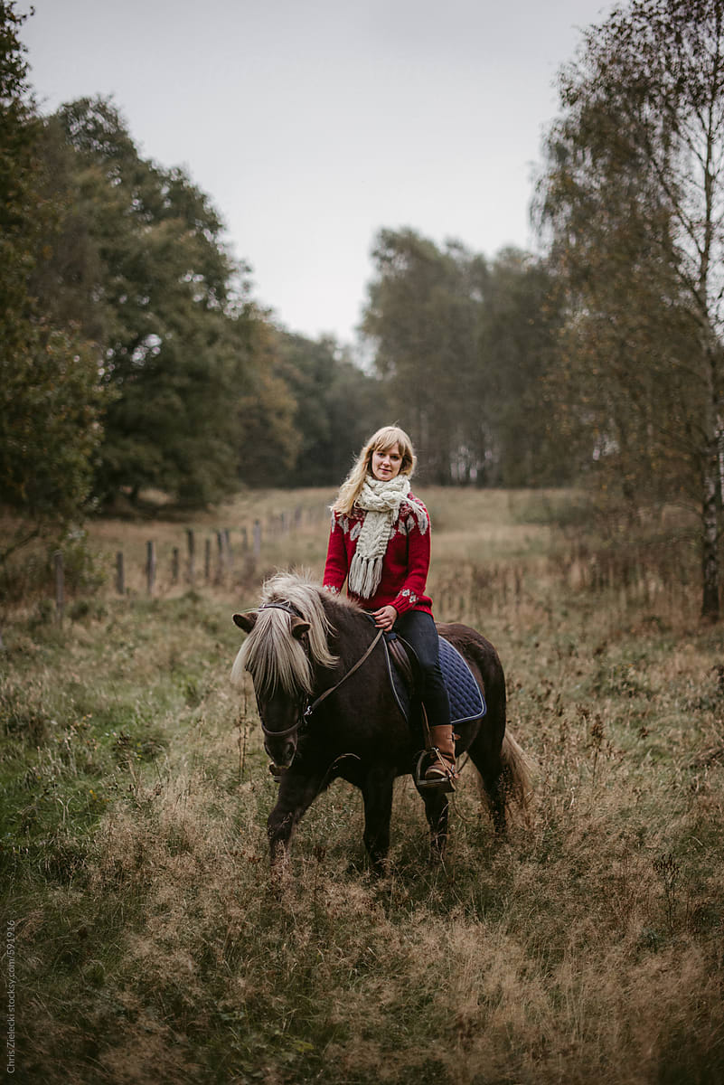 Woman riding horse in countryside