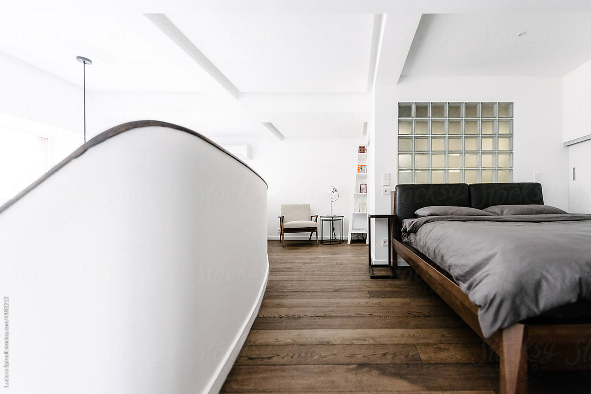 Bedroom mezzanine with wooden bed and toilet with transparent tiles