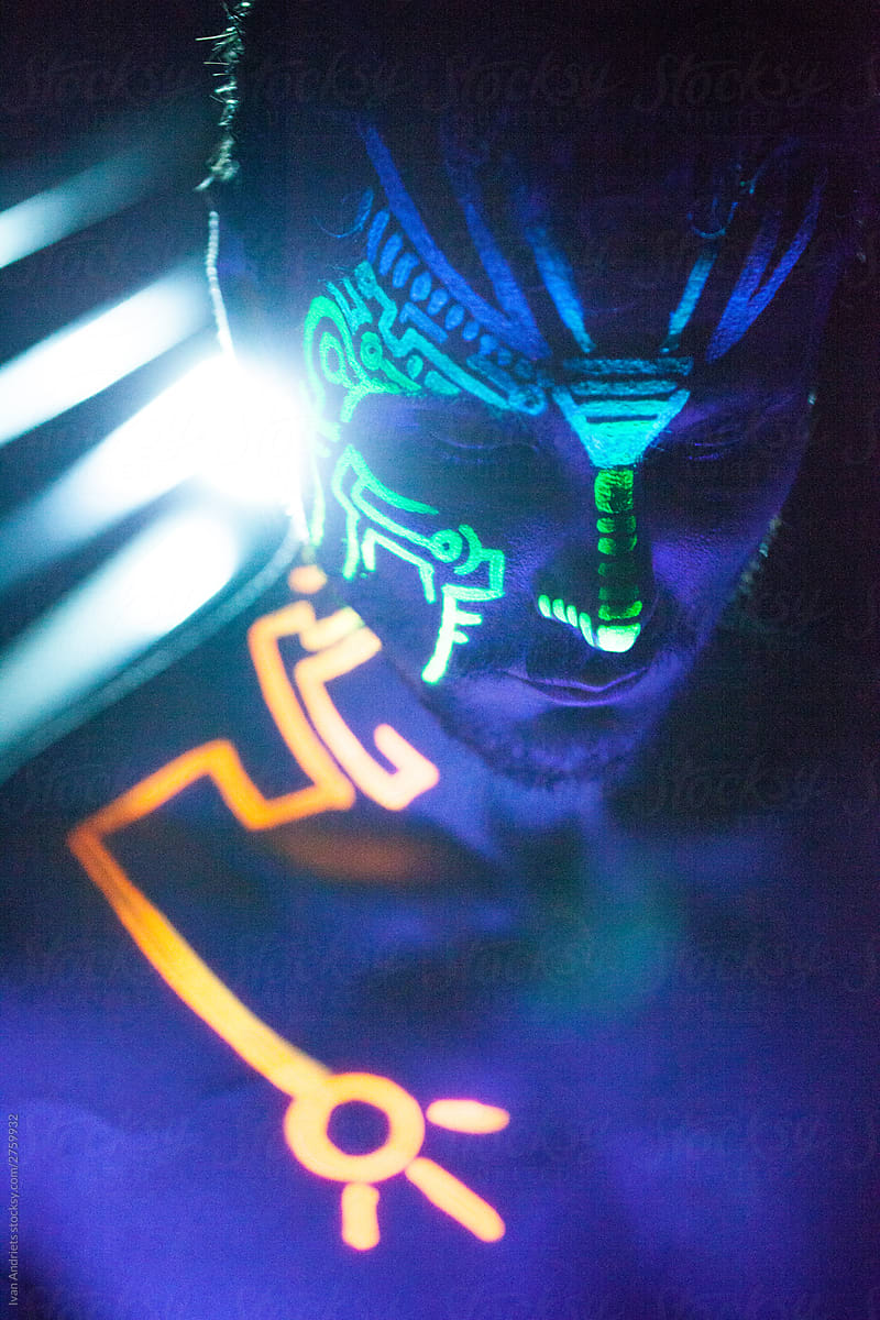 Young man with neon painting on his face