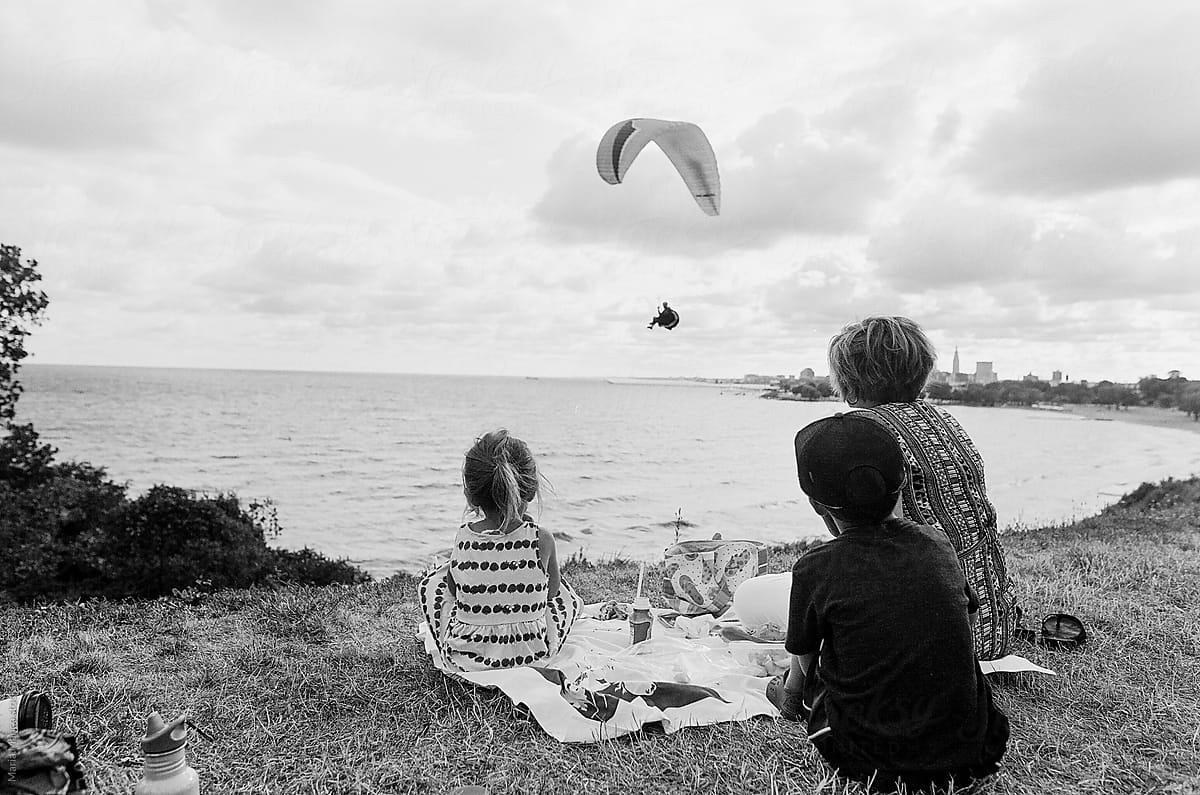 family watches paraglider
