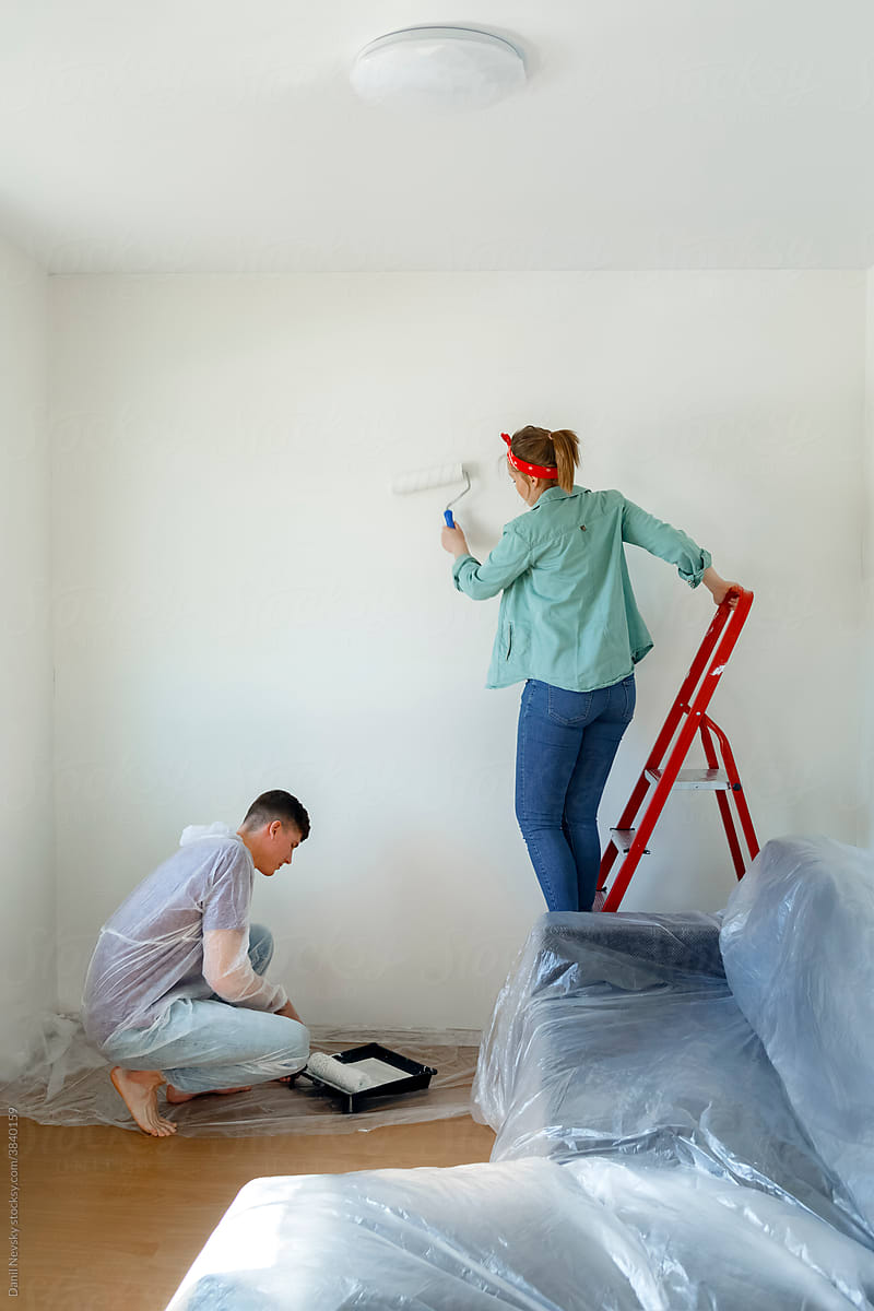 Young couple painting walls at home