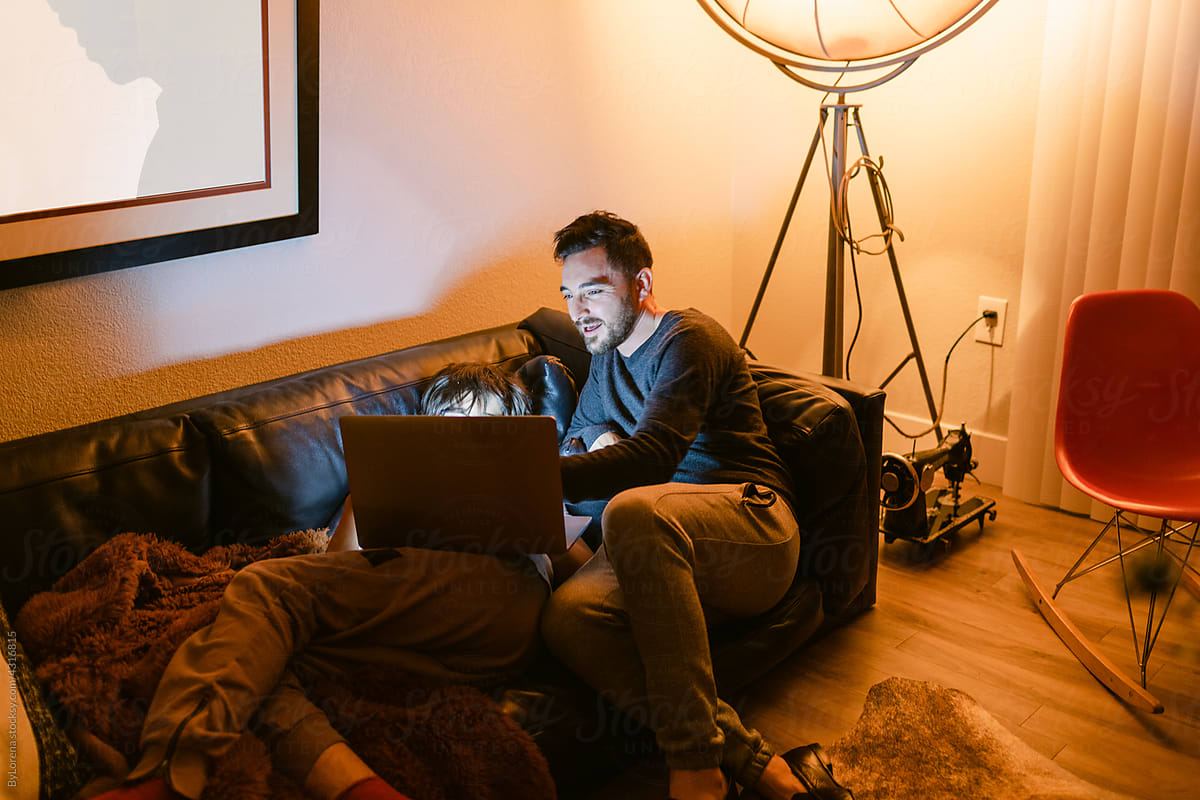 Father and teen boy sharing laptop at night