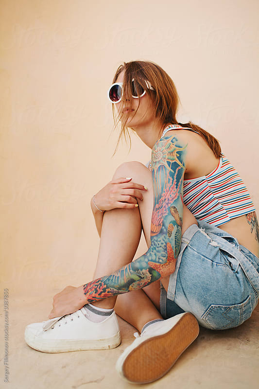 beautiful fashionable tattooed girl with a simple background