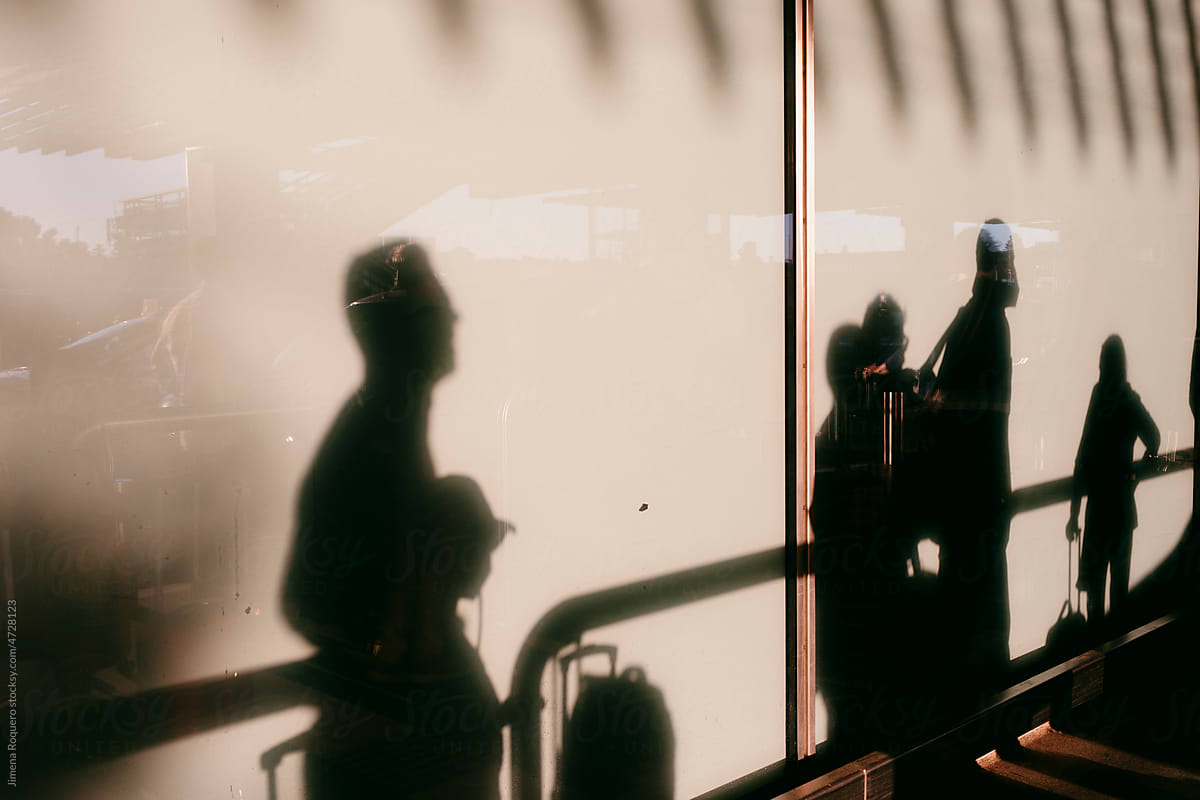 Shadow of group of people carrying luggages in airport terminal