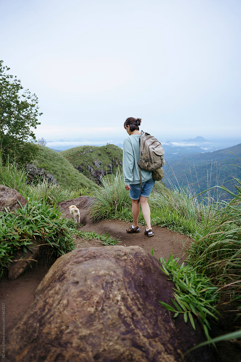A woman enjoys a trip in the mountains with her dog