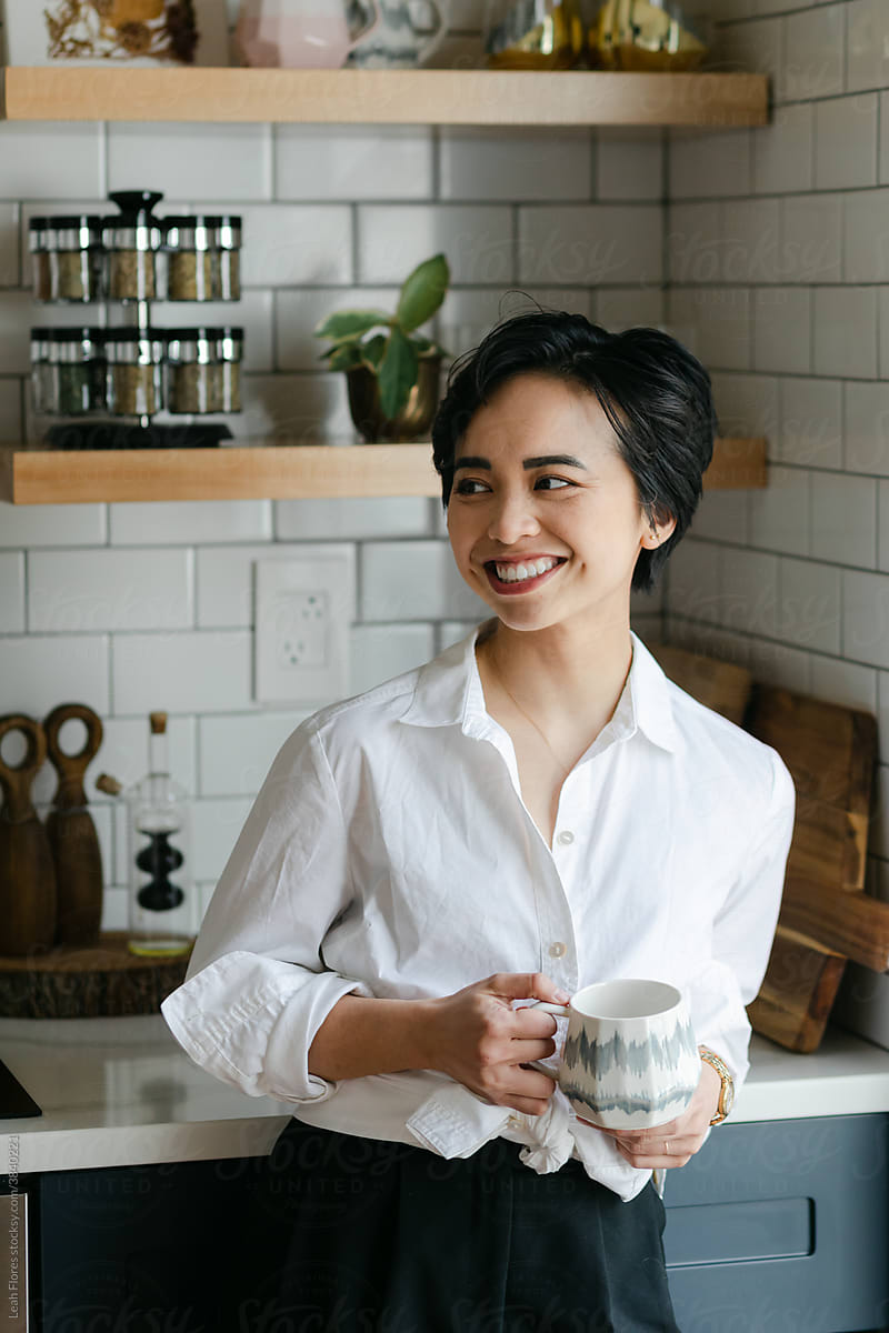 Smiling Woman in Kitchen with Coffee