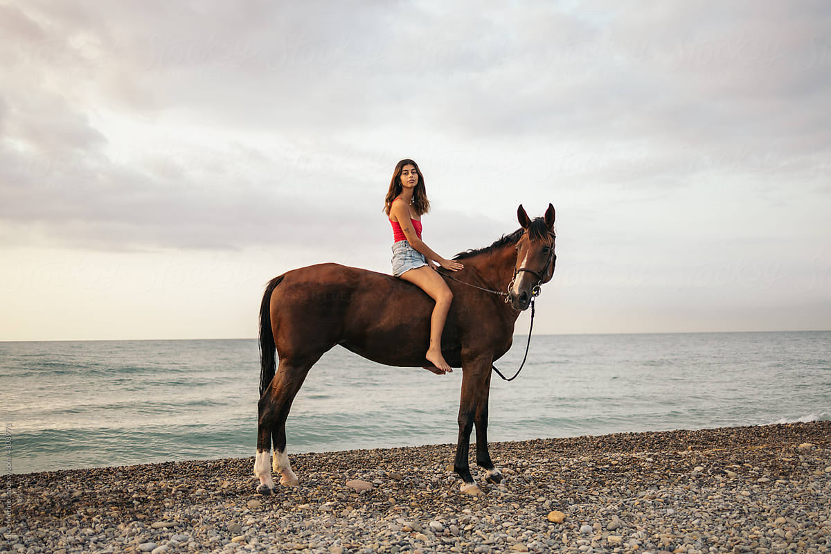 Girl riding a horse on an empty beach