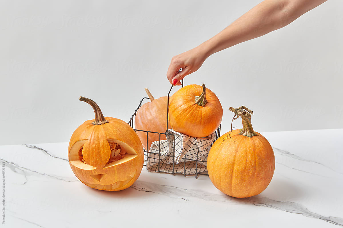 Carved Halloween pumpkin in wire basket.