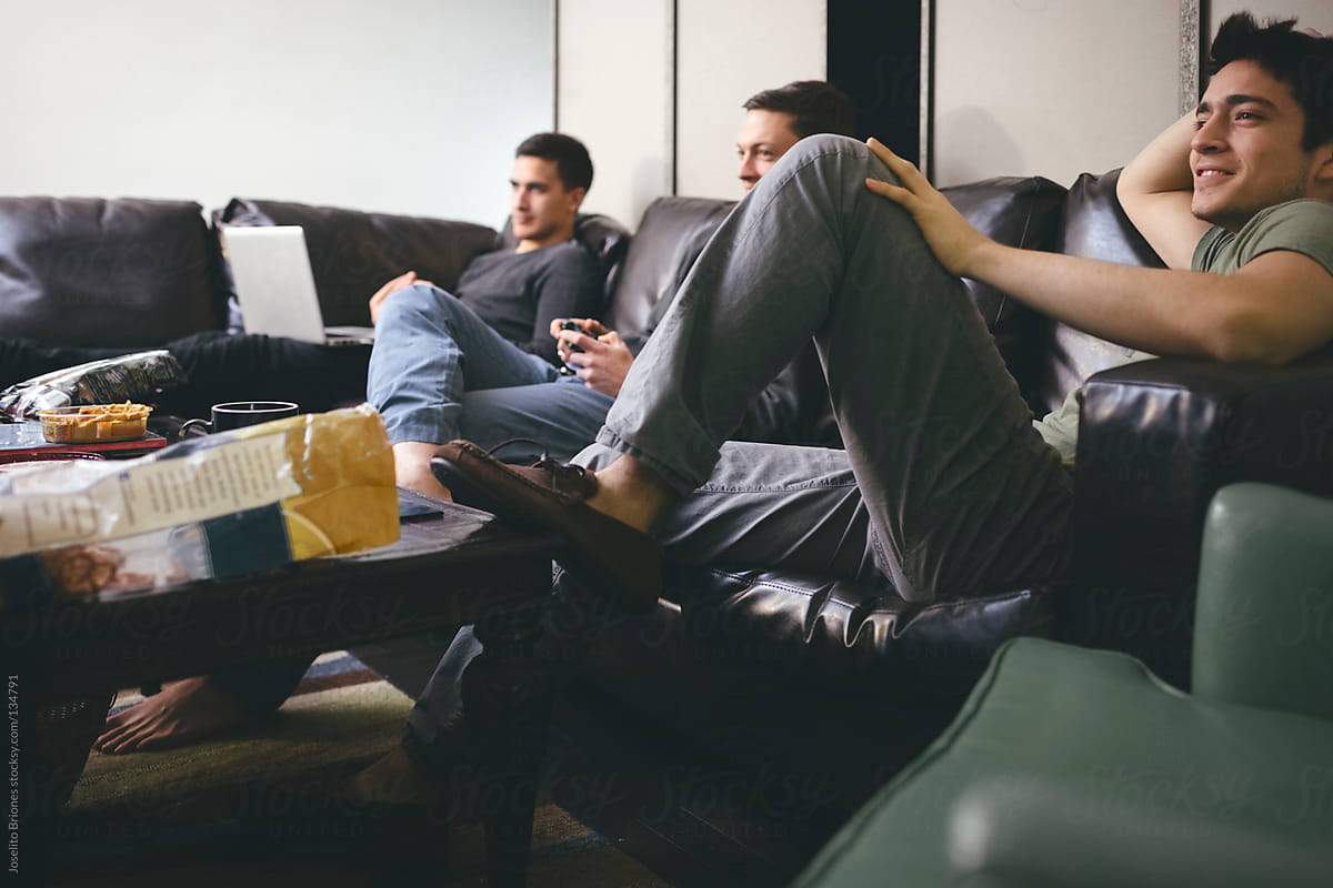 Friends Roommates Playing Video Games Together in Couch of New York Apartment