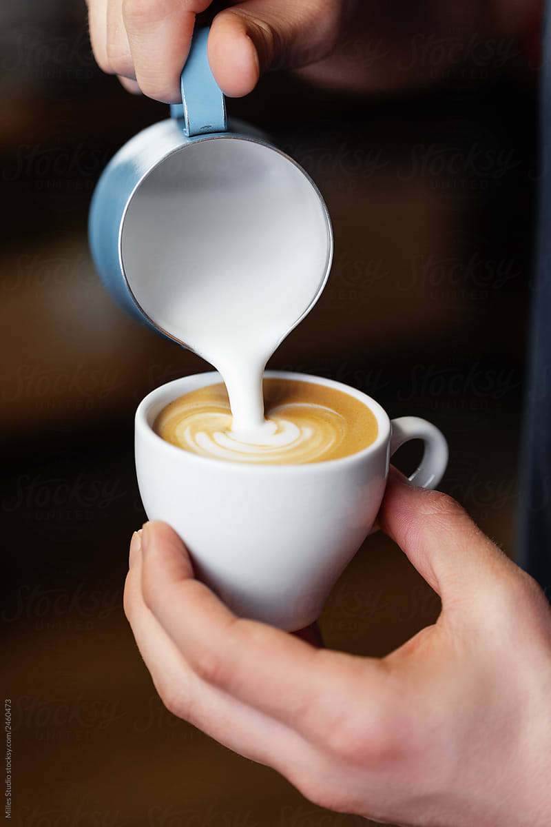 Faceless barista making latte