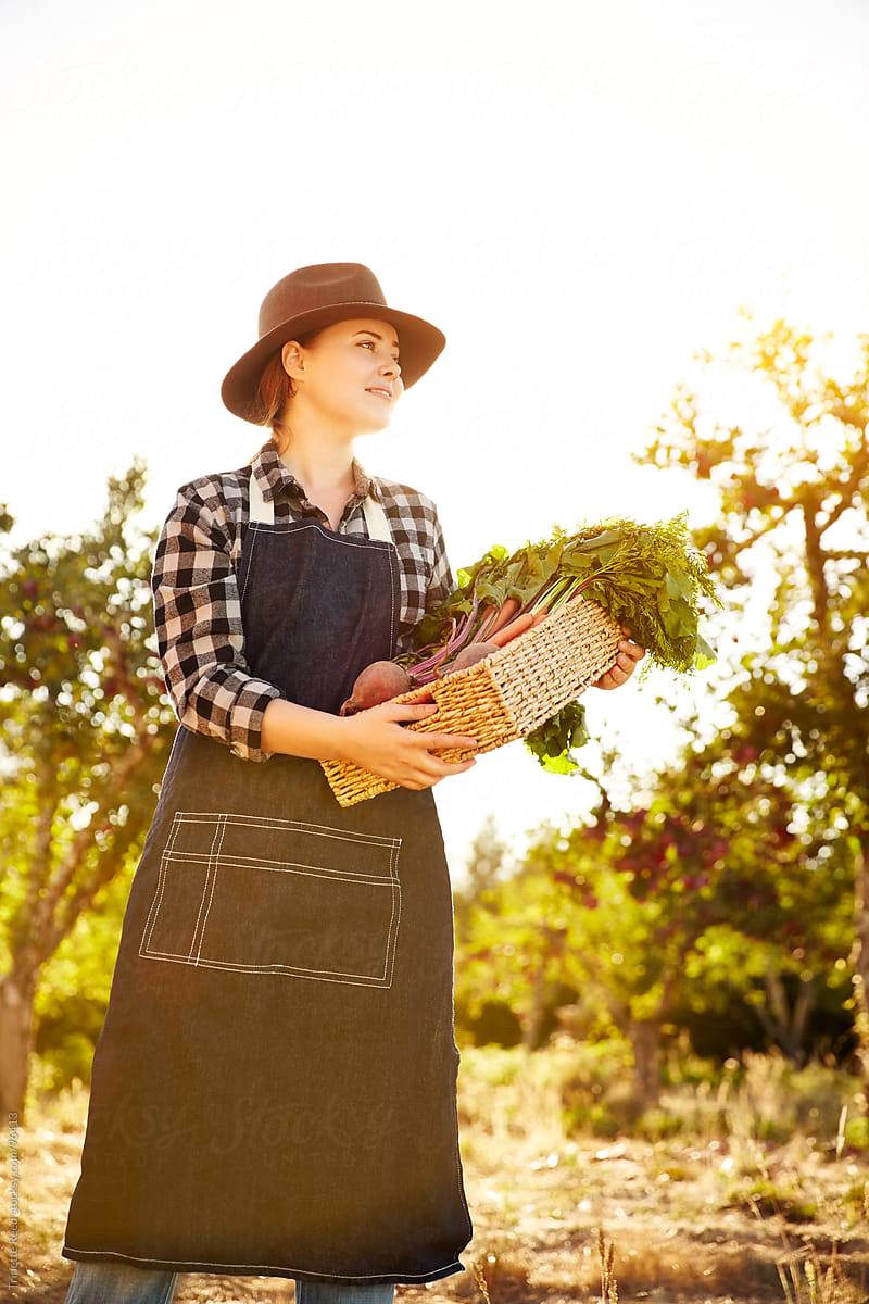 Woman farmer holding organic veggies on a farm