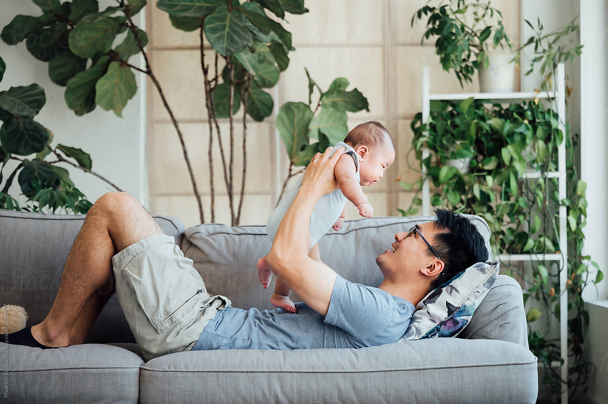 Asian father lifting baby son