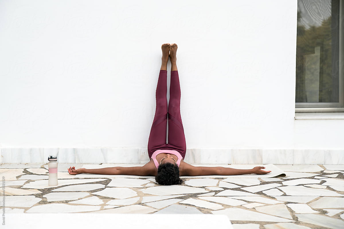 Black female doing yoga on terrace