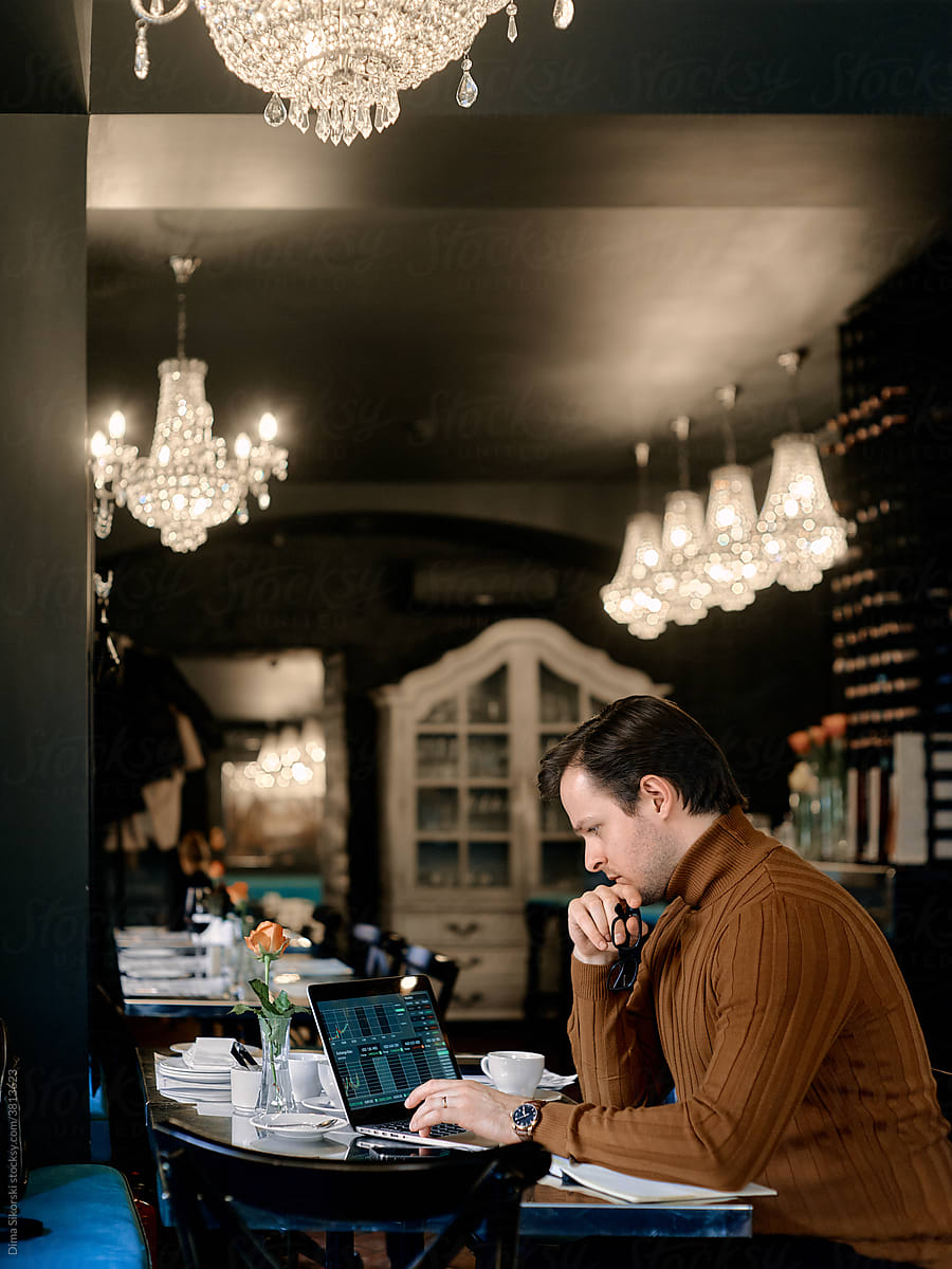 a man with a laptop in a cafe
