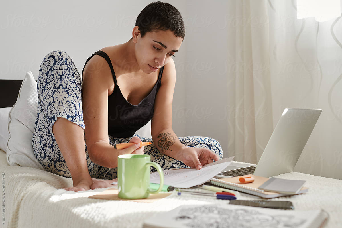 Woman doing homework at bed