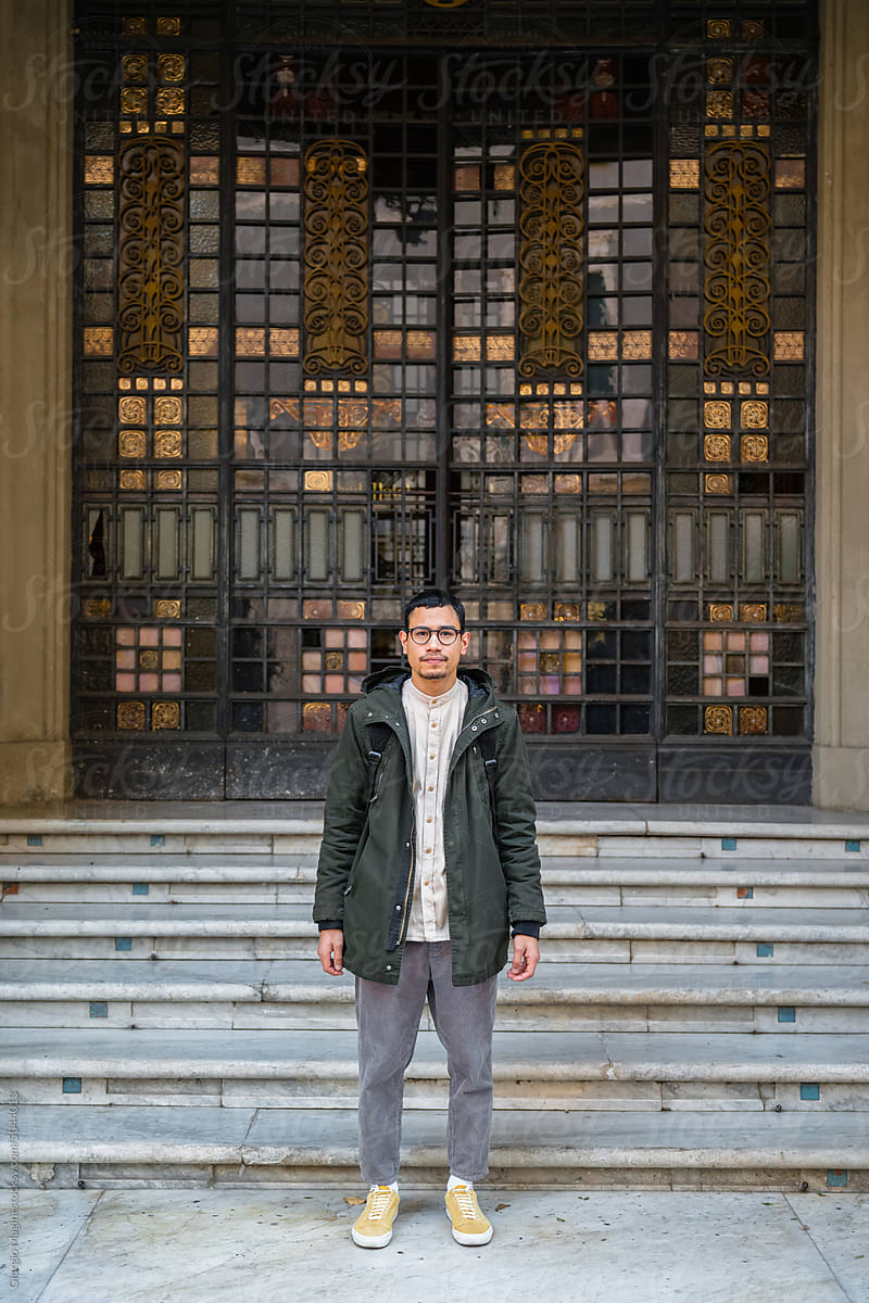 Young Man Portrait Standing in Front of a Large Gate