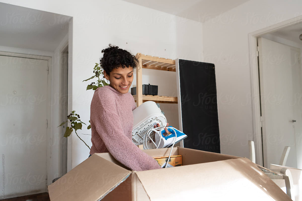Woman Opening Boxes In Moving Home