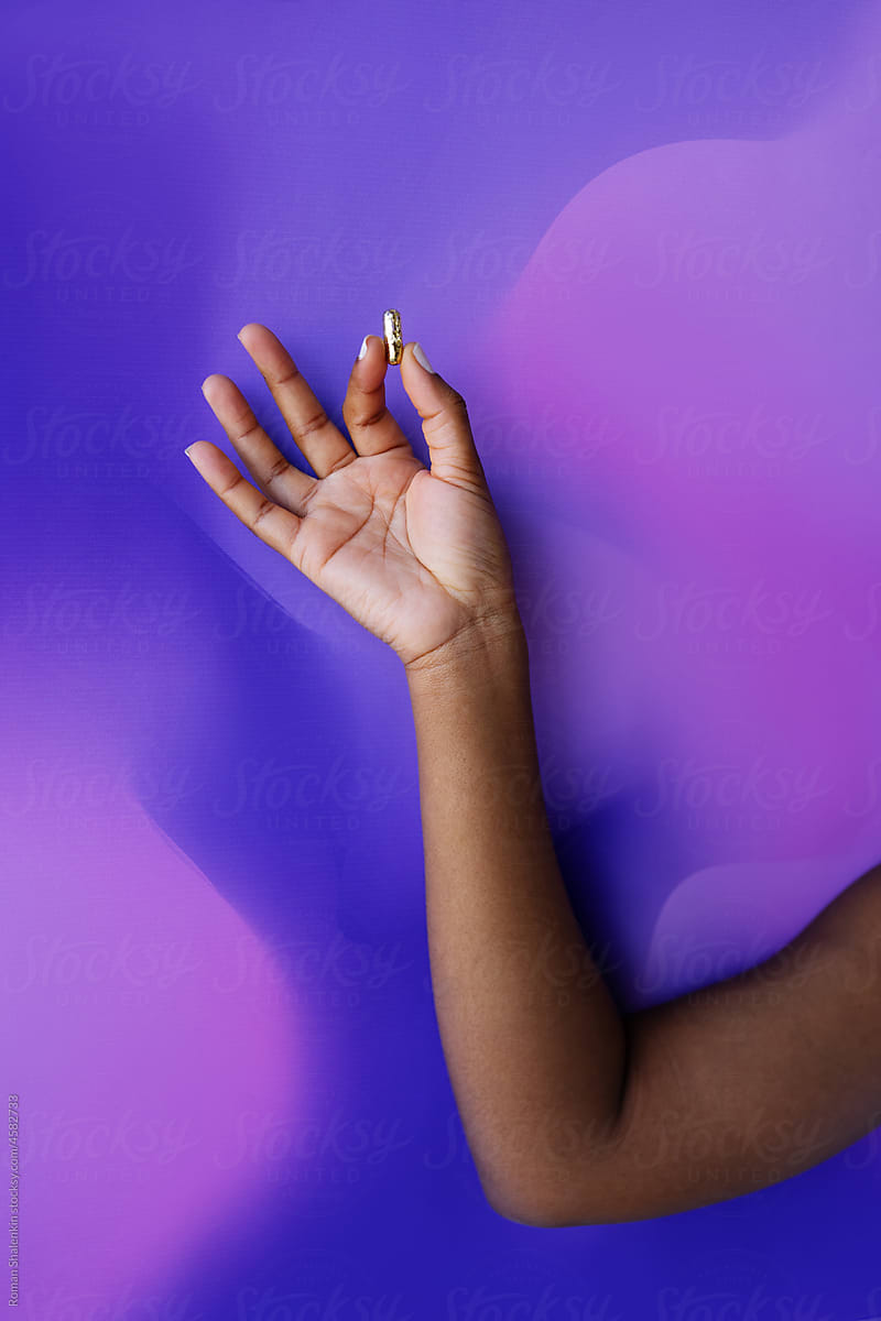 Crop black woman showing golden capsule