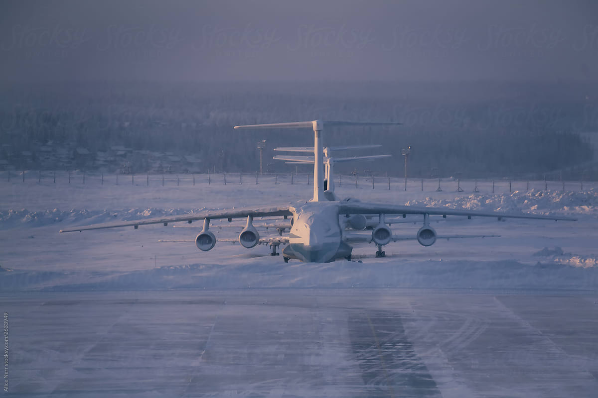 Huge cargo airplane covered with snow at the airport in winter