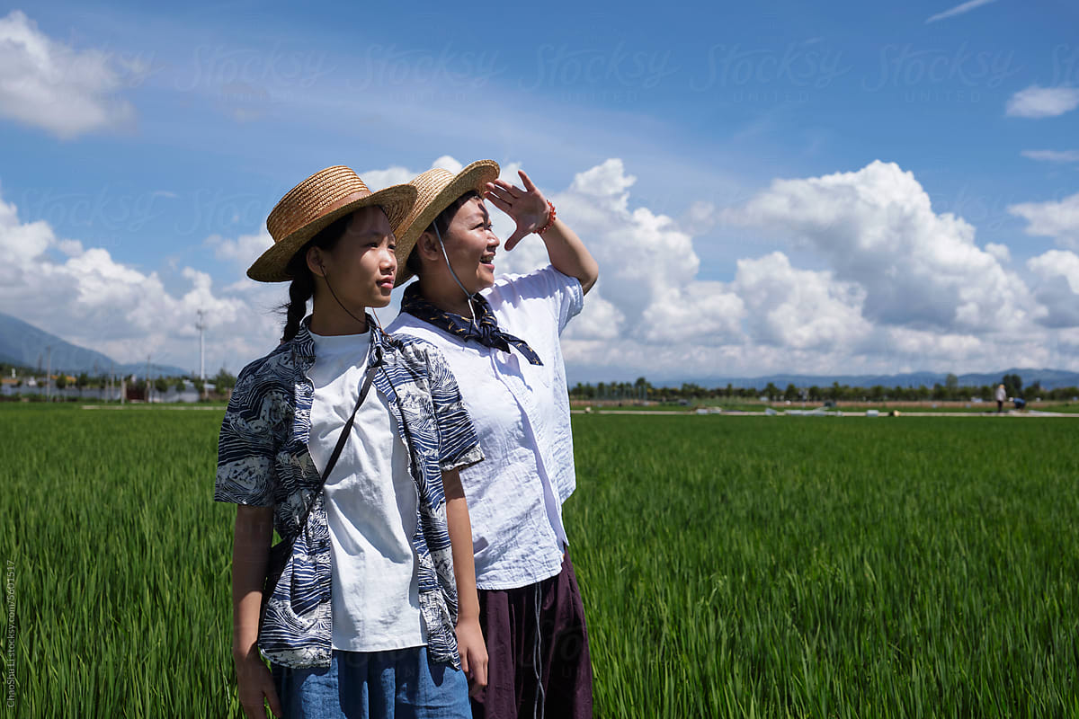 Asian mother and daughter, standing in the rice field